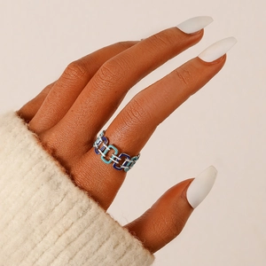 Detail of elegant enamel geometric chain ring with blue and white drip oil on finger