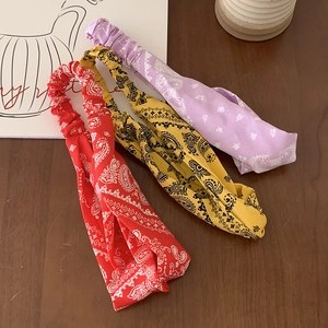 Three vintage paisley paisley printed elastic headbands in red, yellow, and purple colors