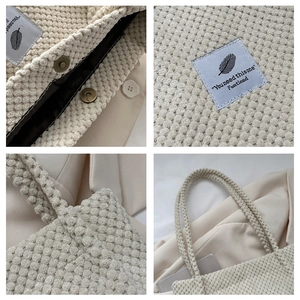 Detail view of beige corduroy tote bag showing waffle texture, straps, and magnetic closure