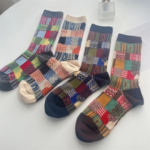 Flat lay of four colorful vintage plaid mid-calf socks with knitted geometric patterns