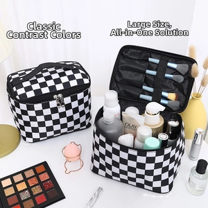 Detail view of checkerboard makeup bag with double zippers and makeup brush compartments