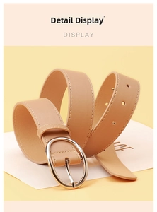 Detail view of a light brown PU leather belt with silver oval buckle on yellow background