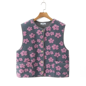 Detailed view of grey sherpa fleece vest with pink floral pattern and front pockets