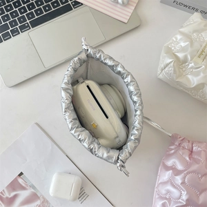 Detail view of a silver metallic drawstring camera bag showing spacious inner storage