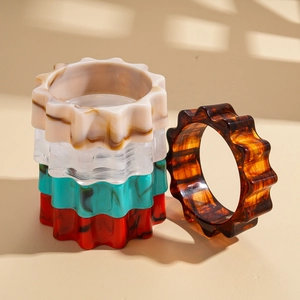 Exaggerated wavy gear acrylic resin bangles with marble textures and amber finishes