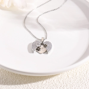 Silver heart pendant necklace with shimmering zircons on a white minimalist plate