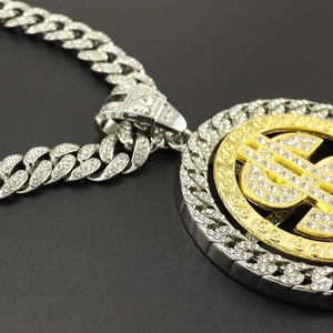 Détail d'une chaîne cubaine hip-hop argentée et pendentif dollar doré rotatif serti
