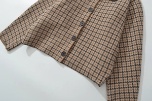 Detail der Strickjacke mit Hahnentrittmuster, Harzknöpfen und Rippstrickbündchen