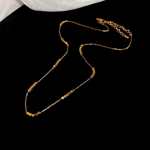 Detail of adjustable golden beaded square link chain necklace with lobster clasp
