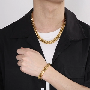 Men's titanium steel gold Cuban link chain necklace and bracelet set worn by a model