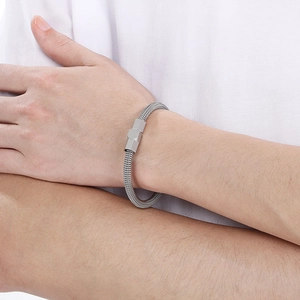 Detail of silver mesh bracelet with hexagonal magnetic clasp on model's wrist