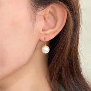 Close-up of elegant 925 sterling silver pearl drop earrings worn on a female model
