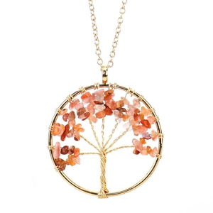 Detail of handmade gold wire tree of life pendant with red natural crystal stones