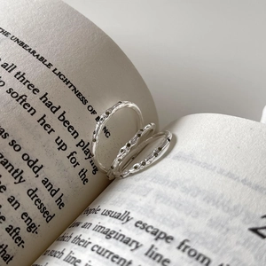 Macro shot of 925 silver hammered rings with zircon accents on vintage book pages