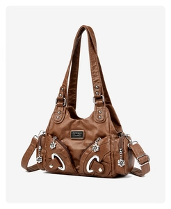 Detailed view of brown vintage soft leather tote with dual tassels and silver logo plaque