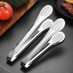 Three stainless steel kitchen tongs with filter holes on a marble countertop background