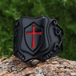 Macro detail of medieval knight ring featuring red cross on black shield and sword carving
