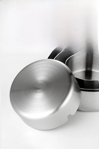 Detail of stainless steel ashtray showing anti-slip concave base and smooth polished edges