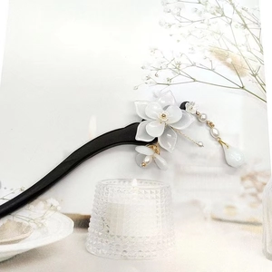 Detail of white magnolia flower hairpin with freshwater pearl and golden metal tassels