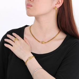 Parure de bijoux serpent dorée avec yeux verts et grosse chaîne sur un mannequin