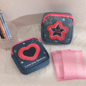 Detail of denim mini pouches with pink plush star and heart embroidery showing textures