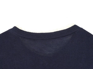 Close-up of navy blue knit cardigan neckline with delicate white lace trim detail