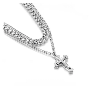 Close-up of double-layered silver chain necklace with a sparkling diamond cross pendant