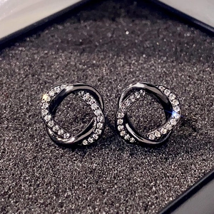 Macro shot of interlocking black metal earrings with shimmering pavé zircon stones