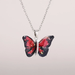 Close-up of butterfly pendant with red-black gradient wings and gold leaf detailing