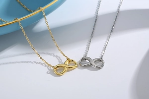 Detail of gold and silver infinity symbol necklaces on elegant display props