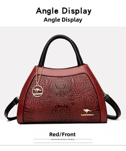 Macro view of red crocodile texture handbag with gold kangaroo emblem and metal details