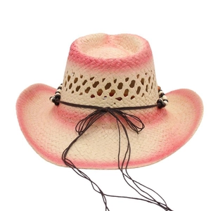 Detail of hand-woven straw cowboy hat with pink gradient edges and beaded trim