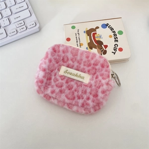 Dettaglio della pochette in peluche maculata rosa con cerniera in metallo ed etichetta