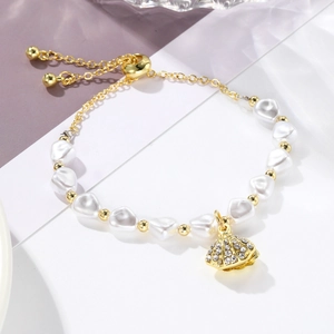 Detail of baroque pearl bracelet with gold shell pendant and sparkling rhinestones inlay