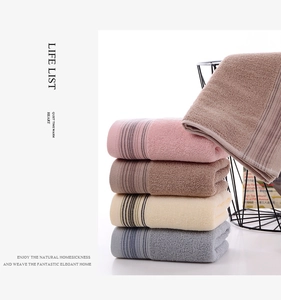 Detail view of cotton towels in four colors neatly folded inside a black metal wire basket
