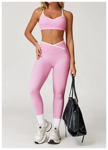 Detail van roze yoga-set met hoge taille, witte contrastrand en V-vormige kruisband