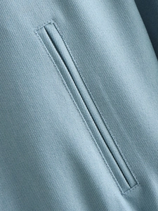 Macro view of detailed welt pocket on light blue twill fabric motor jacket