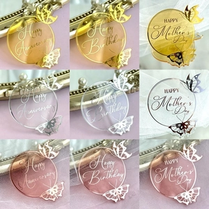 Detailed macro view showing gold and silver acrylic cake toppers with butterfly engraving