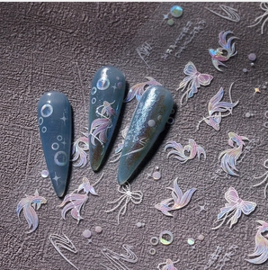 Macro detail of laser holographic fish and butterfly nail stickers on blue-grey nails