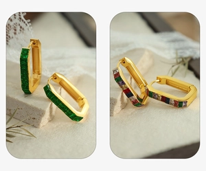 Detailed view of gold rectangular earrings with green and multicolor zircon inlays