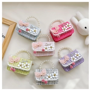 Detail of colorful plaid tweed kid purses with pearl handles and silk ribbon bows