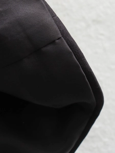 Detailed close-up of high-quality black nylon fabric showing professional stitching edges