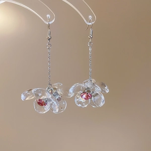 Detailed close-up of acrylic flower earrings with pink rhinestone center and silver chain