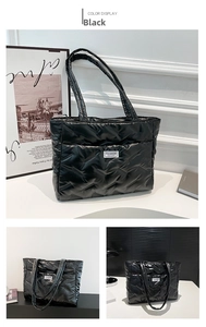 Detail of black quilted puffer tote bag featuring a Fashion Instinct logo patch