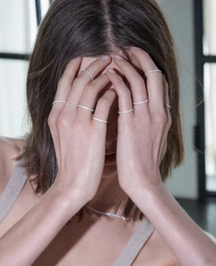 Close-up of minimalist silver stacking rings with pavé diamonds on model's hand