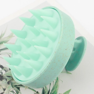 Detail of mint green silicone scalp massager brush with eco-friendly textured handle