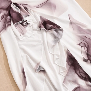 Detail of purple floral chiffon print on white fabric with elegant ruffle layers
