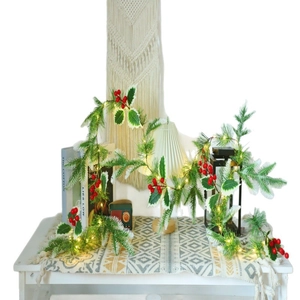 Christmas pine needle garland with red berries and warm LED lights for festive table decor