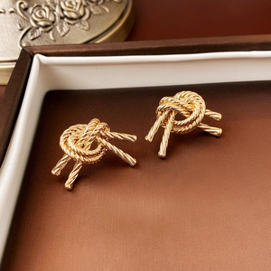 Vintage gold knot pearl earrings displayed in a classic brown jewelry gift box
