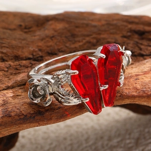 Detail of gothic silver rose engravings and coffin-shaped red stones on heart ring